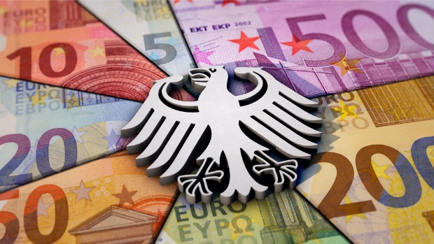 Deutscher Bundesadler als Symbol vor einer Fläche aus Euro-Banknoten in verschiedenen Werten