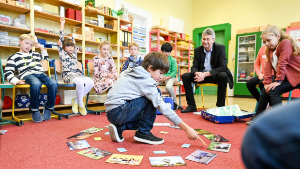 Klasse mit Grundschulkindern und Kultusminister Michael Piazolo